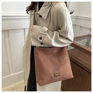 Detailed view of vintage frosted suede bucket bag shown on a model wearing a trench coat