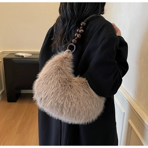 Close-up of fuzzy khaki faux fur crescent bag with dark wood bead strap detail