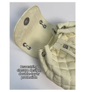 Dettaglio dello zaino trapuntato crema con chiusura a patta e coulisse in argento
