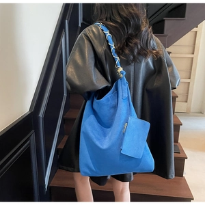 Vue détaillée du cabas en daim bleu Klein avec bandoulière chaîne et pochette assortie