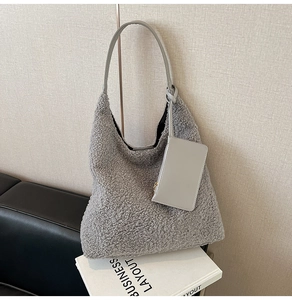 Detail of grey fuzzy tote bag with textured faux fur fabric and matching leather strap