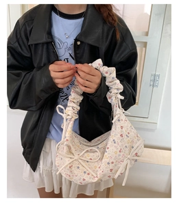 Détail du sac à fleurs avec nœuds décoratifs et poignée froissée pour femme