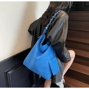 Détail du cabas en daim bleu avec bandoulière en chaîne et petit porte-monnaie