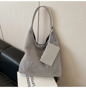 Detail of grey teddy fleece hobo bag with matching leather handle and mini pouch charm