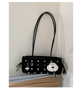 Detail of black polka dot velvet shoulder bag with silver heart charm and plush donut keychain