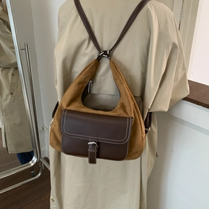 Detail view of suede patchwork backpack with brown leather pocket and contrast stitching