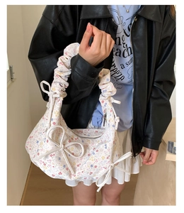 Détail d'un sac floral avec poignées plissées et rubans nœuds en tissu de coton doux