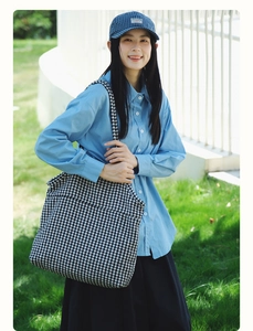 Outdoor shot of a black and white houndstooth tote bag with large capacity for women