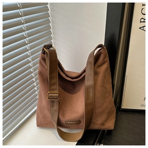 Detail of vintage brown suede shoulder bag with wide strap and golden metal buckle