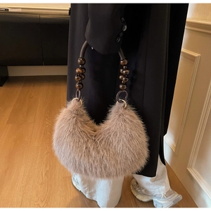 Close-up of brown faux fur handbag with bohemian wooden bead handle detail
