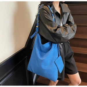 Détail du cabas en daim bleu avec bandoulière en chaîne et mini pochette assortie