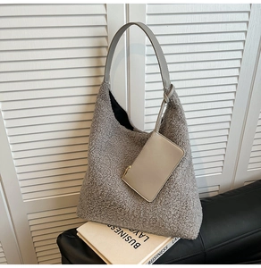 Detail of grey fuzzy faux fur tote bag showing plush texture and small matching pouch