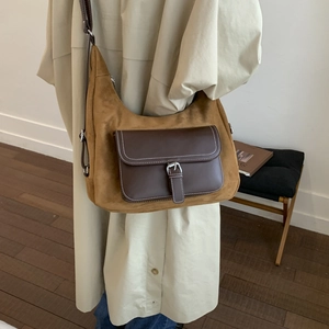 Detail view of vintage brown patchwork crossbody bag with silver buckle and suede texture