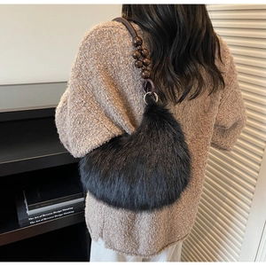 Detailed view of black faux fur shoulder bag with wooden beads and leather strap texture