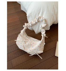 Détail du sac croissant en toile fleurie avec double nœuds et anse froncée style chouchou