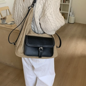 Detail of retro khaki suede shoulder bag with black leather pocket and stitching