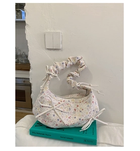 Détail du sac à main floral avec poignées froncées et nœuds décoratifs en ruban
