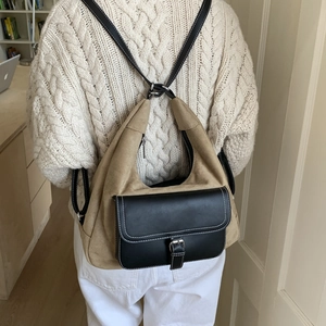 Detail of khaki suede and black leather patchwork backpack with contrast white stitching