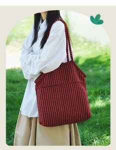 Outdoor shot of red and black houndstooth tote bag in knit tweed texture with shoulder strap