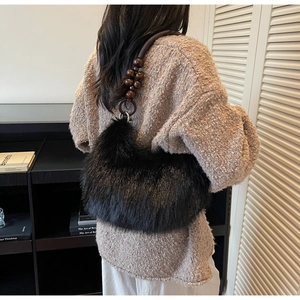 Detailed close-up of faux fur handbag with dark brown wooden bead handle and texture
