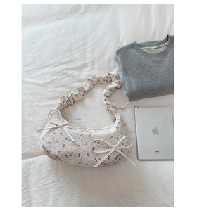 Vue détaillée du sac floral avec nœuds décoratifs et bandoulière plissée élégante