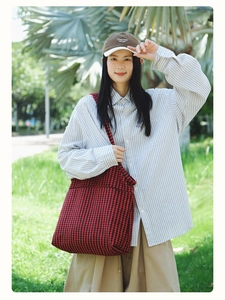 Outdoor shot of a large red and black houndstooth tote bag for Japanese casual styling