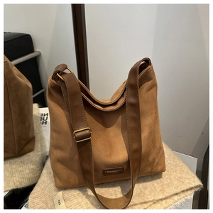 Detail of vintage matte brown hobo bag with leather label on soft knit blanket