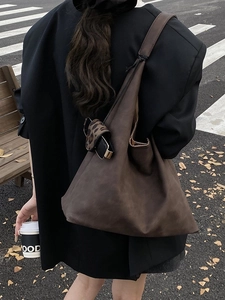 Retro deep brown matte leather tote bag with a leopard print charm in a street setting