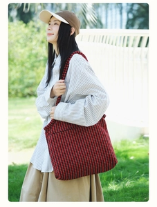 Detail of red and black houndstooth pattern fabric on a spacious tote shoulder bag