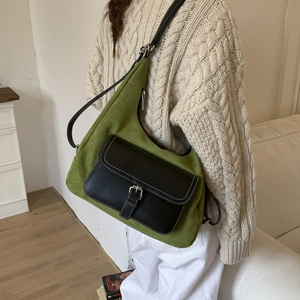 Detail of vintage green matte bag with black leather front pocket and silver metal buckle