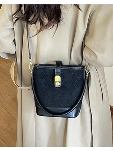 Classic black quilted bucket bag with gold lock and chain strap for crossbody wear