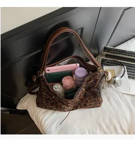 Spacious interior of leopard print tote bag holding a tablet, water bottle and umbrella