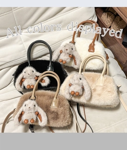 Close-up of fluffy handbags in black, cream, beige, and coffee with plush rabbit charms
