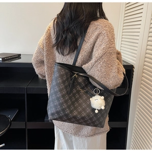 Λεπτομέρεια γκρι καρό τσάντας tote με βελούδινο γούρι και μαύρα χερούλια στον ώμο