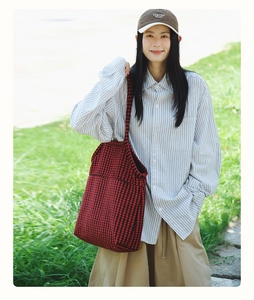 Detailed view of red and black houndstooth knit pattern on a large commuter tote bag