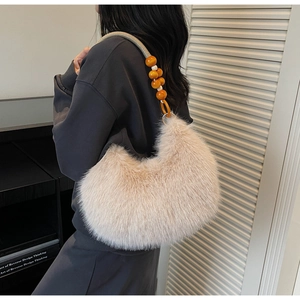 Detail of hobo bag featuring dense faux fur and braided strap with wooden beads