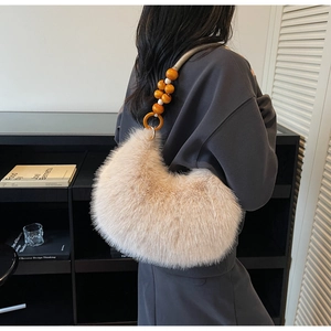 Detail of beige faux fur crescent bag with decorative round wooden bead shoulder strap