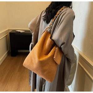 Détail du grand cabas en daim caramel avec bandoulière chaîne et mini pochette