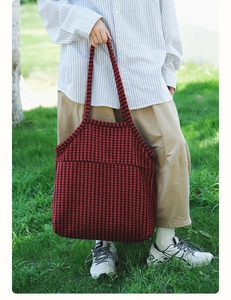Detailed texture of red and black houndstooth pattern on a large knit tote bag