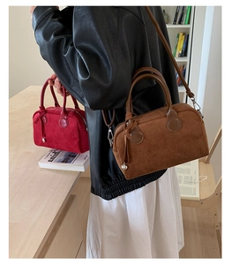 Primer plano detallado de los bolsos Boston retro en ante mate marrón y burdeos
