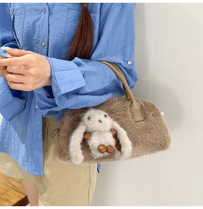 Detail of a brown faux fur handbag featuring a plush white bunny and leather handles