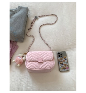 Detail der rosa gesteppten Handtasche mit Silberkette und Plüsch-Anhänger