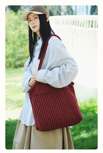 Detail of red and black houndstooth tote bag featuring thick woven texture and neat stitching