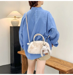 Chic beige fuzzy crossbody bag with a cute rabbit pendant shown on a model