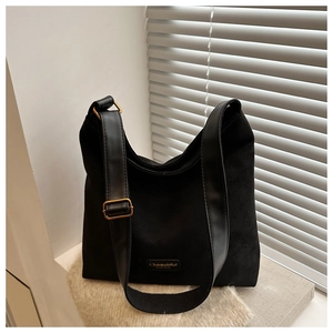 Detail of black frosted tote bag with adjustable leather strap and golden buckle