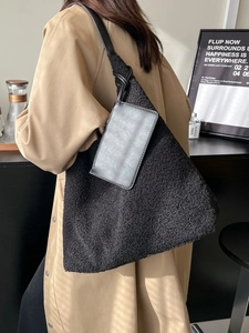 Large black plush tote bag with slim shoulder straps and small leather pouch detail
