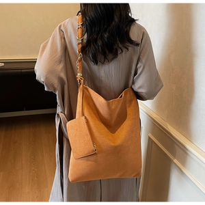 Sac fourre-tout orange en suédine avec pochette assortie dans un décor intérieur chic