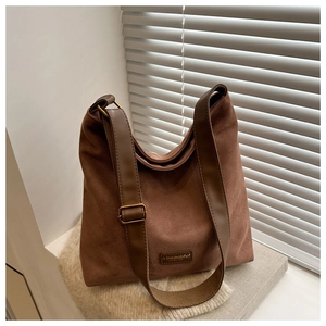 Close-up of vintage brown frosted suede tote with leather logo and metal buckle detail