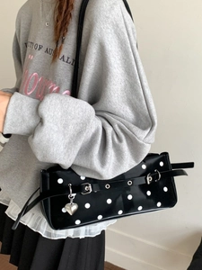 Chic black polka dot baguette bag with silver heart charm and metal eyelet belt decoration