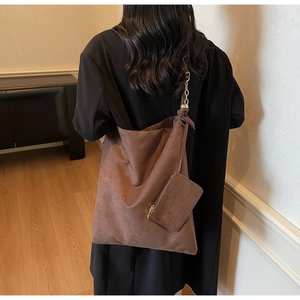 Détail du sac cabas en daim marron chocolat avec chaîne en métal et petit porte-monnaie